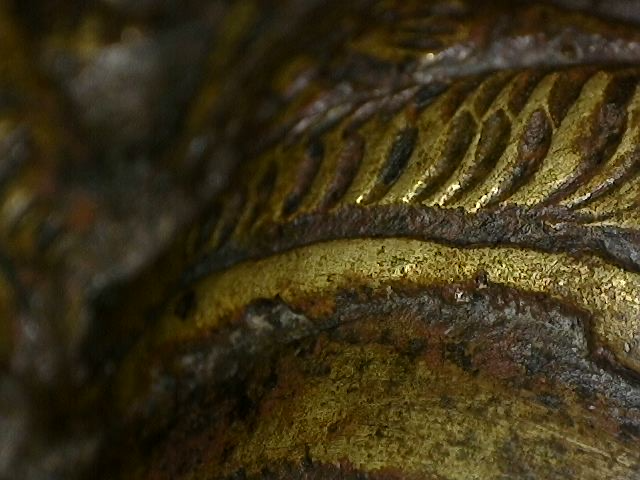 Microscoopdetail van rituele contactslijtage op bronzen Brahma-beeld