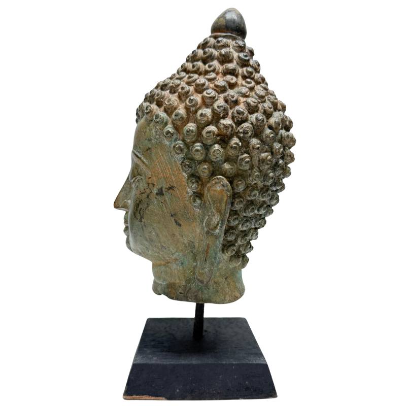 Detail van bronzen boeddhahoofd met rustige spirituele expressie