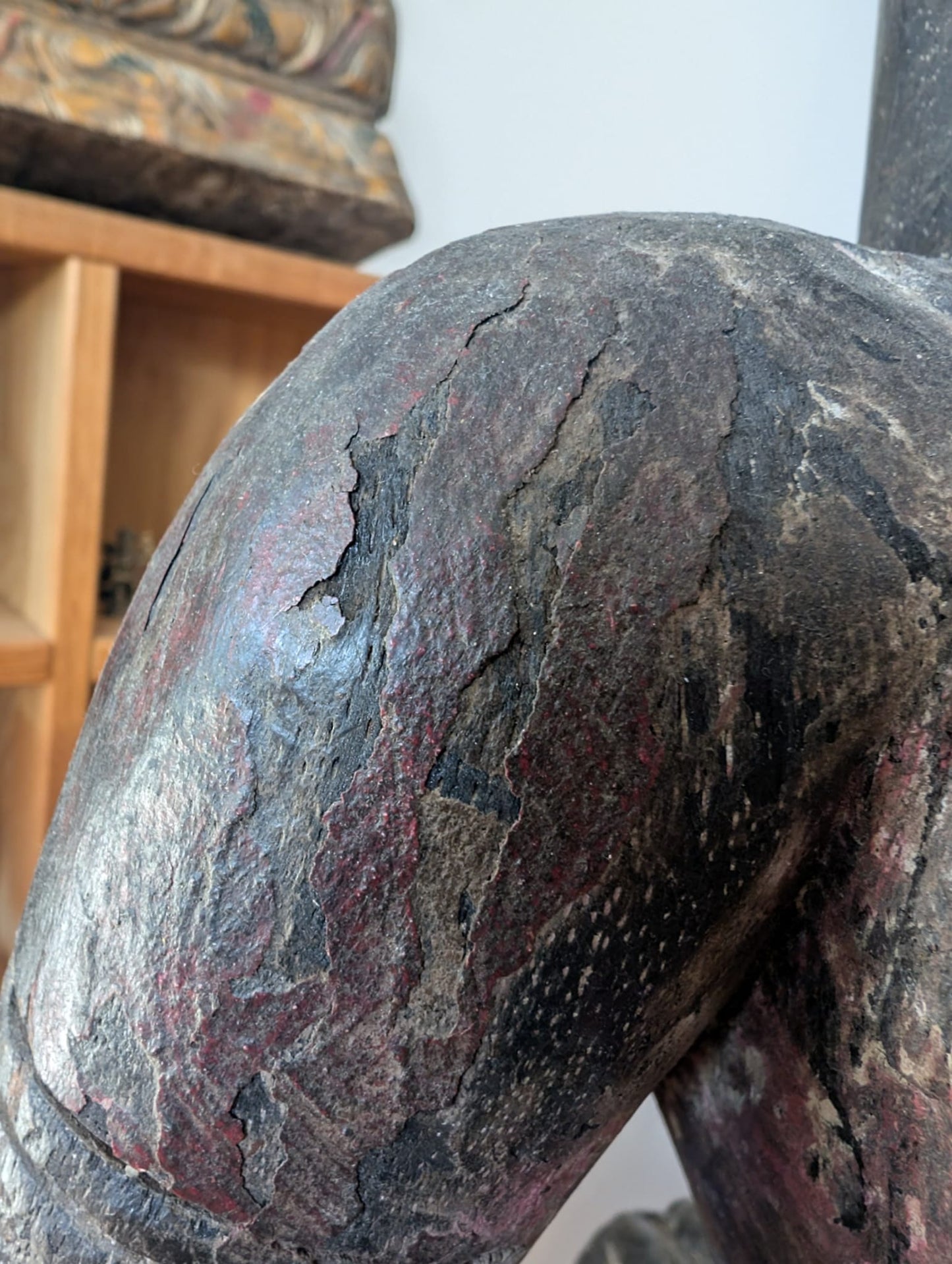 Detail van houten Lakshmi beeld uit Nepal met structuur, patina en craquele in het oppervlak