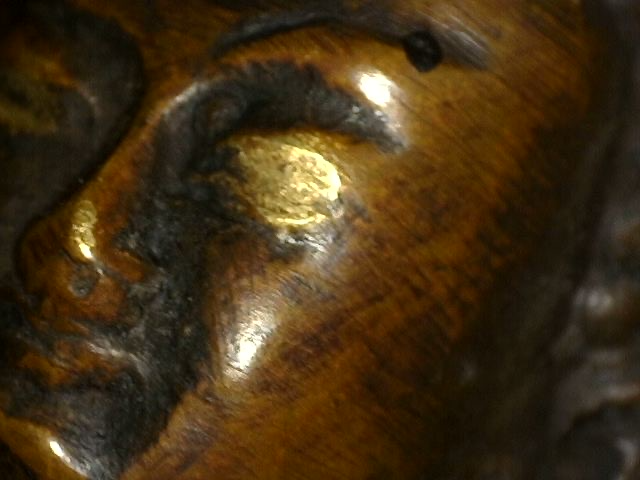 Microscoopdetail van verguldingsresten op antieke bronzen Boeddha met dhyana mudra